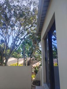 a door to a house with a fence and trees at Peaceful Nest in St Lucia +2 photos