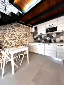 a kitchen with a white table and a stone wall at Perla Loft in Seriate