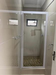 a shower with a glass door in a bathroom at Peaceful Nest in St Lucia