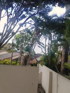 a white fence with trees and a mountain in the background at Peaceful Nest in St Lucia