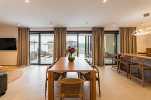 a dining room and living room with a table and chairs at Villa Carbonia in Kolan