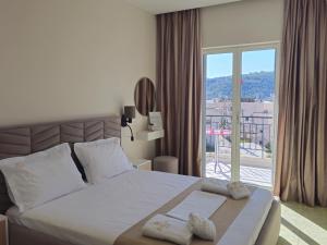 a bedroom with a large bed and a large window at ARILEO ROOMs in Himare