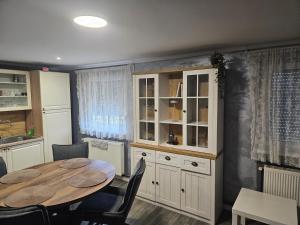 a kitchen with a table and chairs and a cabinet at Kuća za odmor 204 jezero Šoderica in Legrad