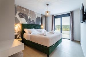 a bedroom with a bed and a large window at Villa Carbonia in Kolan