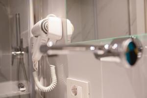 a hair dryer is hanging on a wall at Zoe Hotel in Prishtinë +31 photos