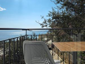 a table and a chair on a balcony with the ocean at ARILEO ROOMs in Himare +17 photos