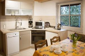 eine Küche mit einem Tisch und einer Mikrowelle in der Unterkunft Haus "Am Mühlheimer Berg" in Mörnsheim