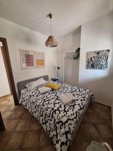 a bedroom with a bed with a black and white comforter at IL VIAGGIO DI COSIMO in San Vito lo Capo