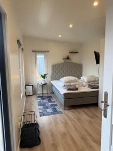 a bedroom with a large bed and a window at Mayas Stuga in Sölvesborg +46 photos
