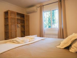 ein Schlafzimmer mit Handtüchern auf einem Bett mit Fenster in der Unterkunft Marimonta in Cómpeta + 31 Fotos