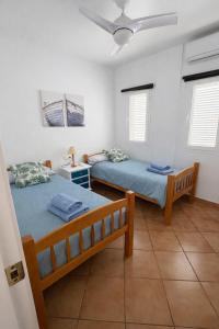 a bedroom with two beds and a ceiling fan at Cala Rajá 5 in La Isleta del Moro +8 photos