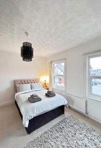a bedroom with a large bed and a chandelier at Charming 2 Bed Terrace in Central Caversham in Caversham