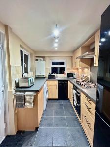 a large kitchen with wooden cabinets and appliances at Charming 2 Bed Terrace in Central Caversham in Caversham