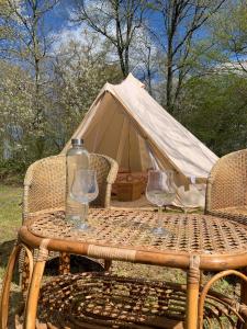 a table with two wine glasses and a tent at Le refuge du Jardinier in Abzac