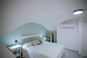 a bedroom with a white bed with pillows on it at Residenza Delle Sirene in Gaeta +20 photos