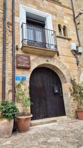 a building with a wooden door and a balcony at El rincon de Adriana in Alquézar