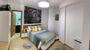 a bedroom with a bed with yellow pillows and a mirror at El rincon de Adriana in Alquézar