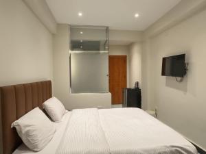a bedroom with a white bed with a flat screen tv at pyramids View Top in Cairo