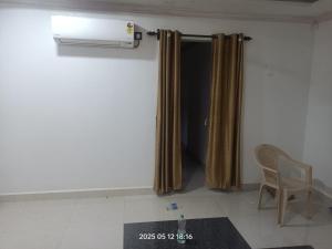 a room with a heater and a chair and curtains at Sada Niwas in Ucassaim
