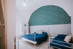 a bedroom with a blue bed and a green wall at Residenza Delle Sirene in Gaeta