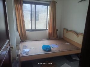 a room with a bed with a window and papers on it at Sada Niwas in Ucassaim
