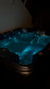 a hot tub with blue water in a dark room at L'étoile d'Arras in Arras