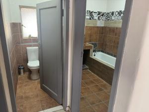 a bathroom with a toilet and a tub at Albam residency kuruman in Kuruman