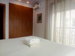 a room with a bed with three towels on it at Esmeralda in Douar el Hafey
