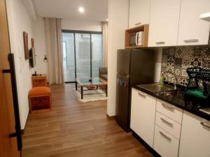 a kitchen with white cabinets and a black refrigerator at Esmeralda in Douar el Hafey