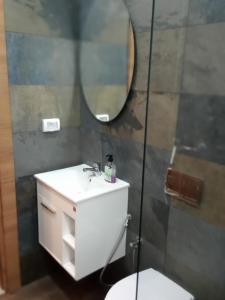a bathroom with a sink and a mirror and a toilet at Esmeralda in Douar el Hafey +13 photos