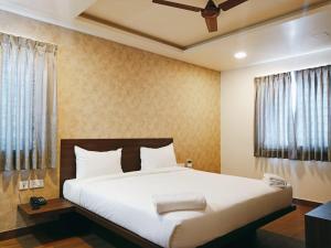 a bedroom with a large bed with white sheets at HOTEL VINTAGE CASTLE in Coimbatore