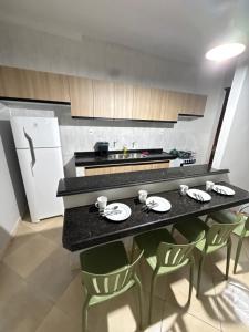 a kitchen with a black counter with chairs and a table at Casa Bragança suíte in Bragança