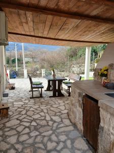 a patio with a table and chairs on a stone patio at Dabanović House in Virpazar