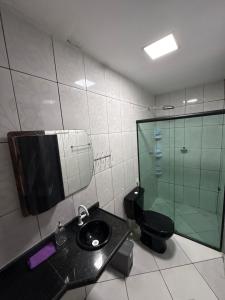 a bathroom with a toilet and a sink and a glass shower at Casa Bragança suíte in Bragança +22 photos
