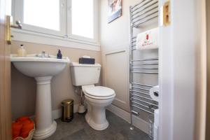 a bathroom with a toilet and a sink and a window at Royal Apartment in Inverness +21 photos