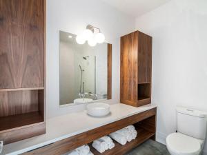 a bathroom with a sink and a toilet and a mirror at Black Arrow Chalet in Courtenay +36 photos