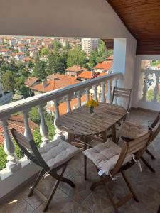 a wooden table and chairs on a balcony with a view at Кума Лиса in Devin