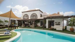 a villa with a swimming pool in front of a house at Casona de Tao in Tiagua