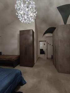 a bedroom with a bed and a chandelier at Casa Muce in Novi Ligure +4 photos