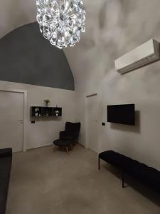 a living room with a chandelier and a chair at Casa Muce in Novi Ligure