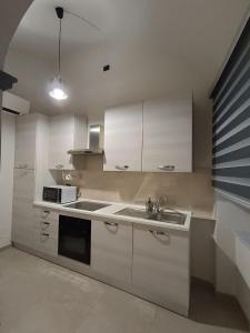 a kitchen with white cabinets and a sink at Casa Muce in Novi Ligure