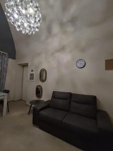 a living room with a couch and a clock on the wall at Casa Muce in Novi Ligure