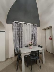 a table and chairs in a room with a window at Casa Muce in Novi Ligure
