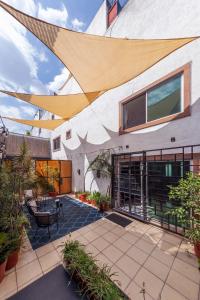 a building with awning over a courtyard with plants at Casa Hidalgo By Mi Querido Coyoacán in Mexico City