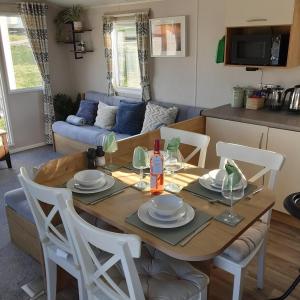 a living room with a wooden table and chairs at Joesphine Newquay Bay 37 in Newquay Bay Resort
