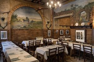a restaurant with white tables and chairs and a mural at My Bed Vatican Museum in Rome
