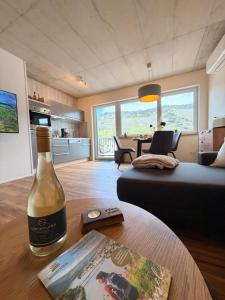 a bottle of wine sitting on a table in a living room at Sonnenufer Apartment & Wein III in Bernkastel-Kues