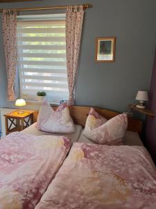 a bedroom with two beds and a window with a window blindiosyn at Apartment Rotdornblüte in Wustrow