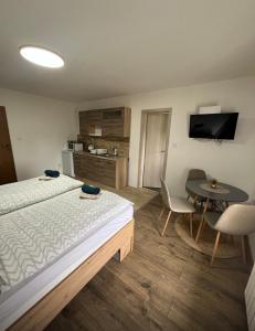a hotel room with a bed and a table and a tv at Penzion Chlumec in Český Krumlov