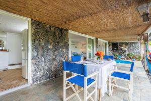 a dining room with a white table and blue chairs at Villas ti creole nogent in Sainte-Rose